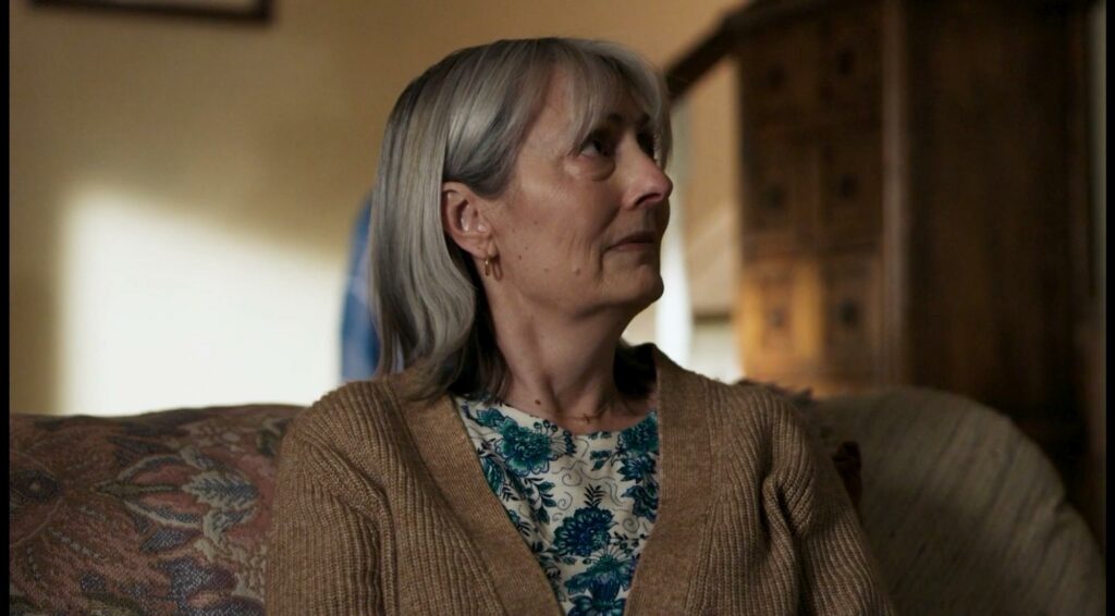 Laureen Smith sitting on a couch in a living room.